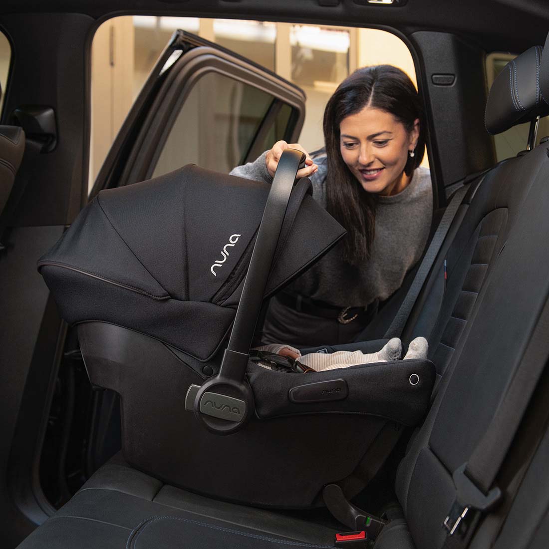 Nuna PIPA Urbn Infant Car Seat - Lifestyle Parent Installing in Vehicle